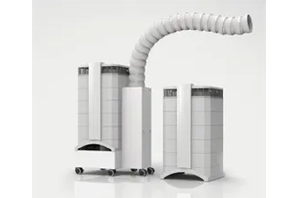 The image shows a white industrial machine with multiple cylindrical components, positioned in front of what appears to be a large duct or pipe, set against a plain background.