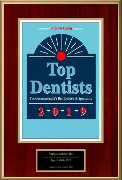 The image shows a framed award plaque with text that reads  TOP DENTISTS 2019  and includes the name of an individual, a logo, and a description of the award as  THE COMMONWEALTH S BEST   FINEST DENTISTS.  The frame is brown with a blue background inside.