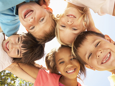 A group of children with various expressions, posing together for a photo.